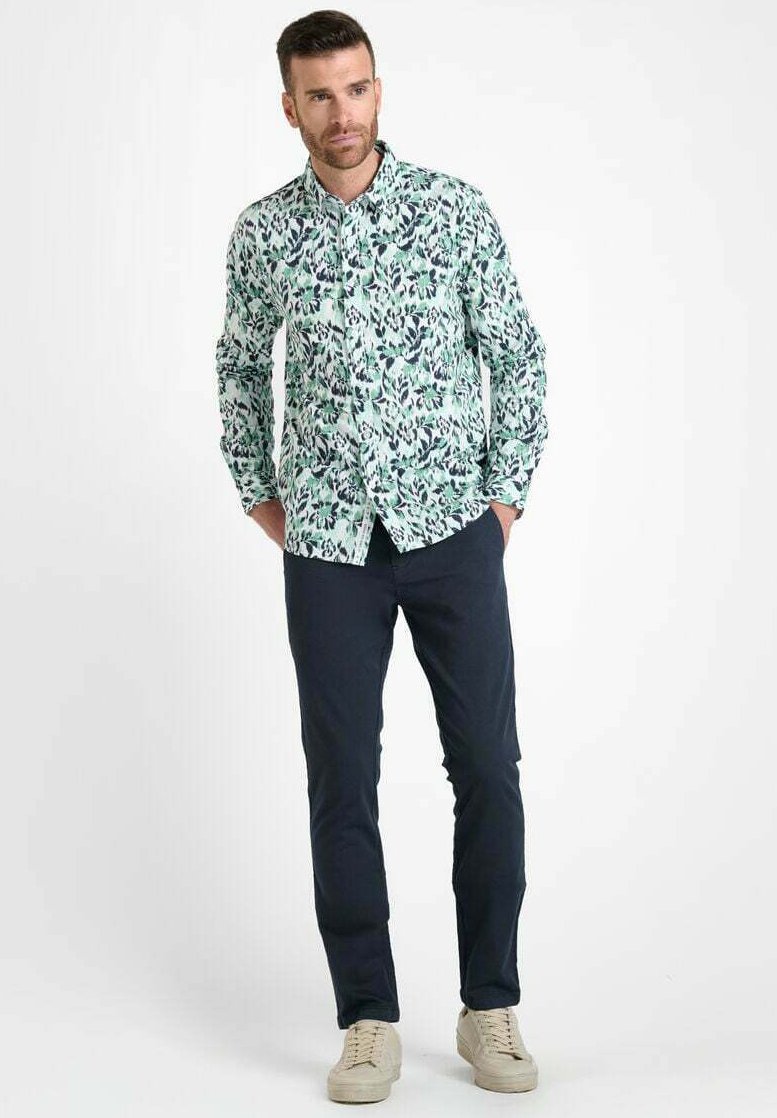 Heren overhemd met knopen in lichtgroen met een bloemenpatroon. Beschikt over lange mouwen, een kraag en een rechte snit, gecombineerd met donkere broeken en sneakers.
