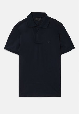 Polo shirt à manches courtes de couleur bleu marine avec col et logo subtil sur la poitrine gauche, posé à plat sur un fond blanc.