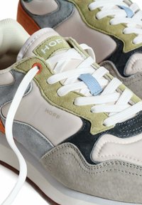 Zapatillas con una mezcla de ante y malla gris, verde y naranja, que cuentan con cordones blancos, una etiqueta con el logo y un diseño texturizado y en capas.