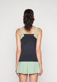 Black athletic dress with a mint green pleated skirt, adjustable mint green straps, and a fitted bodice, showcasing a smooth texture.