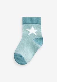 Calcetín de tobillo color azul claro con textura acanalada, puño de un azul más oscuro y un diseño de estrella blanca en el lado exterior.