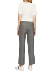 Pantalons ajustés gris avec une jambe droite, comportant une poche arrière, associés à un haut blanc à manches courtes et des baskets blanches.