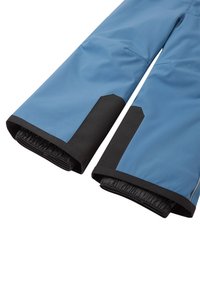 Pantaloni de exterior impermeabili, de culoare albăstruie deschis cu accente negre. Dispune de manșete elastice și zone întărite la genunchi pentru durabilitate.