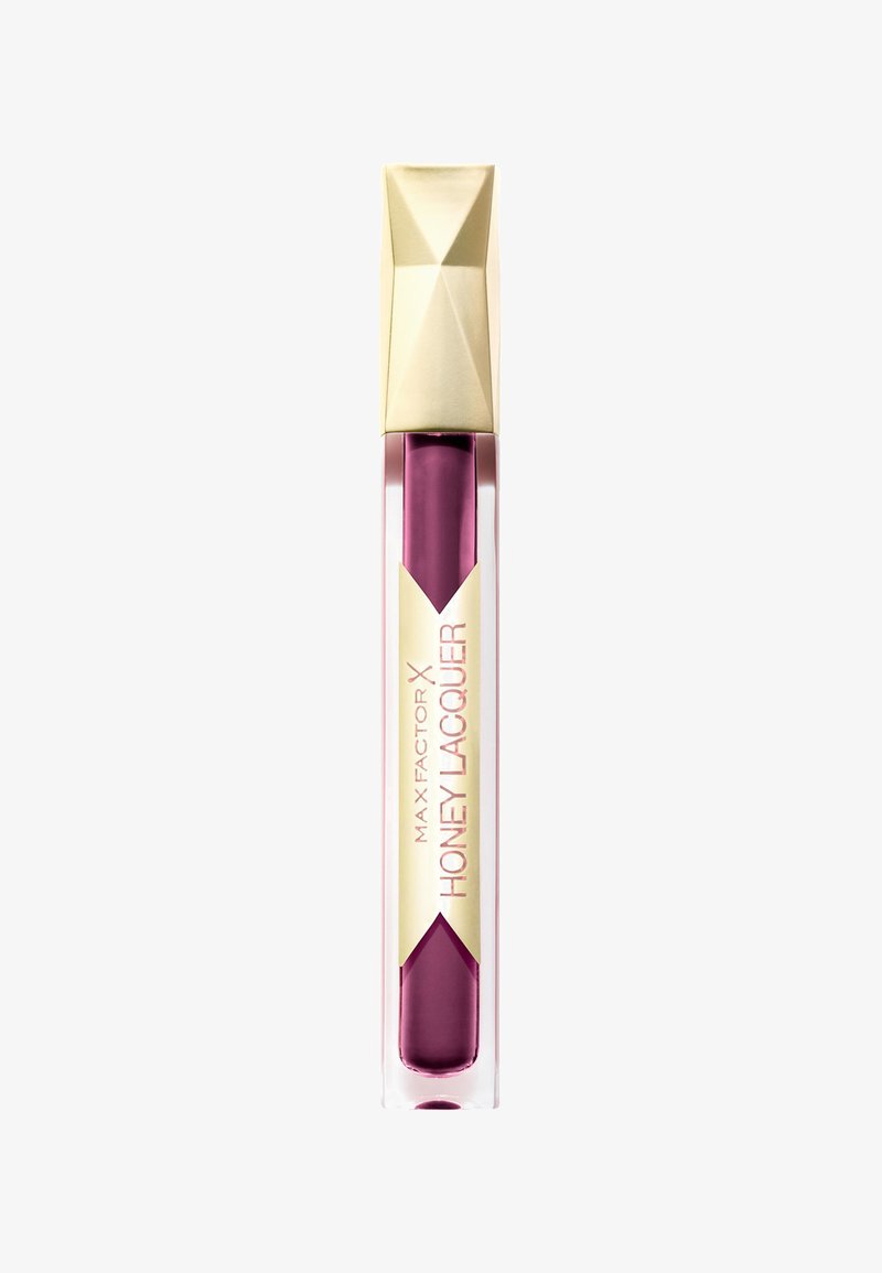 Max Factor Honey Lacquer i en transparent tube med et geometrisk guld-låg, der har en dyb blommefarve og er mærket med pink og guld.