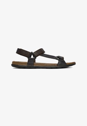 Mørkebrun lædersandal med justerbare stropper, korkfodsål og sort gummisål, vist i sideprofil mod hvid baggrund.