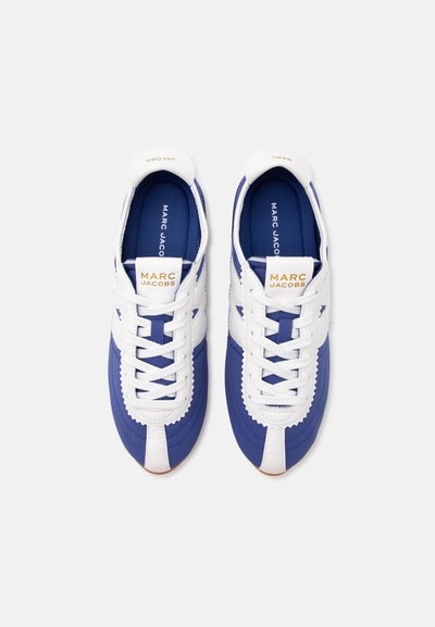 Paire de baskets bleues et blanches Marc Jacobs avec des lacets blancs, vues de dessus sur fond blanc uni.