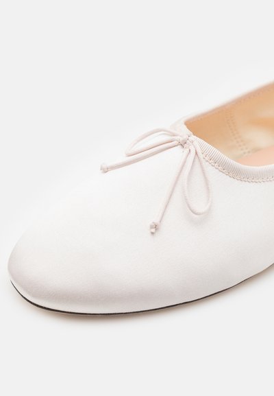 Lyserøde balletflade sko med en glat mat finish, rund tå og en dekorativ sløjfe foran. Blødt inderside og minimal sål.