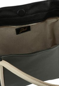 Leren handtas met een zwarte gestructureerde bovenkant, grijze body, beige handvatten, gouden rits en een stoffen voering met een merklabel.