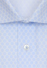 Chemise bleu clair à motif étoile géométrique, col boutonné, avec un bouton blanc à quatre trous visible près du centre.