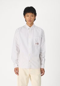 Camicia a righe con strisce beige e azzurro chiaro, dotata di una tasca applicata con logo rosso ricamato sul lato sinistro del petto e polsini con bottone.