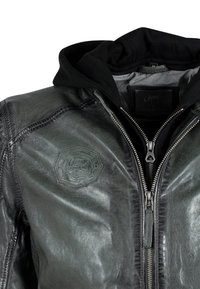 Zwarte leren jack met een grijze capuchon, voorzien van een ritssluiting, een gestructureerde afwerking en een hexagonaal logo-embleem op de borst.