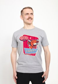Grå bomulds T-shirt med et vintage-inspireret grafisk design af en ko med teksten "La Vache Qui Rit" og farverige accenter i rød og blå.