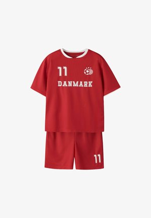 Piros focimez és rövidnadrág fehér szegéllyel, a 11-es szám a mez és a rövidnadrág elején, "DANMARK" felirat és focilabda logó csillagokkal a mez elején.