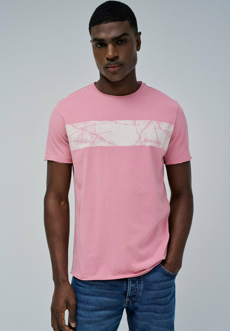 camiseta de algodón rosa con un diseño de rayas horizontales blancas desgastadas y el texto "SALSA JEANS" en el frente; cuello redondo, mangas cortas.