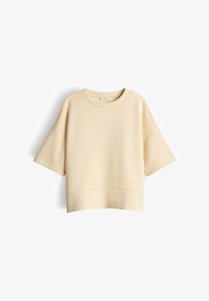 Beige oversized korte mouw sweatshirt met verlaagde schouders en ronde halslijn, weergegeven op een witte achtergrond.