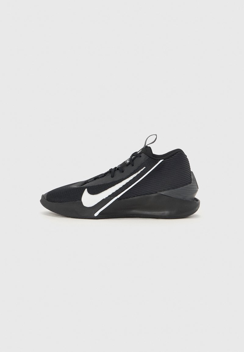 Chaussure de sport noire avec le swoosh blanc de Nike, semelle profil basse et languette avec tirette, vue de côté gauche sur fond uni.