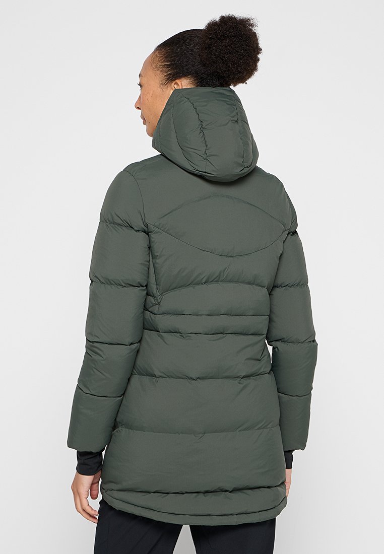 Dunkelgrüner Puffer-Mantel mit Kapuze, der ein gesteppte Design, lange Ärmel und einen längeren rückseitigen Saum für zusätzlichen Schutz bietet.