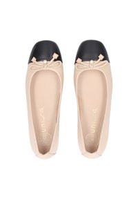 Ballet flats in beige synthetic material with a black patent leather cap toe. Features a bow with a pearl accent on the toe.