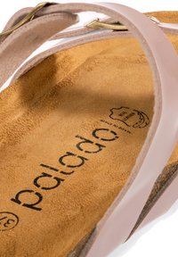 Rosa läder sandal med justerbar rem, mockainlägg och präglad logotyp. Har en mjuk textur och en ljus neutral färg.