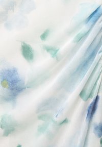Leichtes Gewebe mit einem weißen Grund, das zarte Blumenmuster in Blau- und Grüntönen aufweist und so ein filigranes, strukturiertes Erscheinungsbild erzeugt.