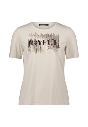 T-shirt beige à manches courtes en tissu doux, arborant un graphisme en sequins "JOYFUL" avec des lignes verticales et des accents décoratifs.
