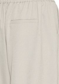 Beige lightweight fabric pants with elastic waistband and a single welt back pocket on the right side.