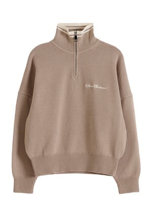 Beiger Strickpullover mit gerippten Bündchen und Saum, Halb-Reißverschluss-Kragen mit weißen Streifen und kleinem kursivem Text auf der linken Brust.