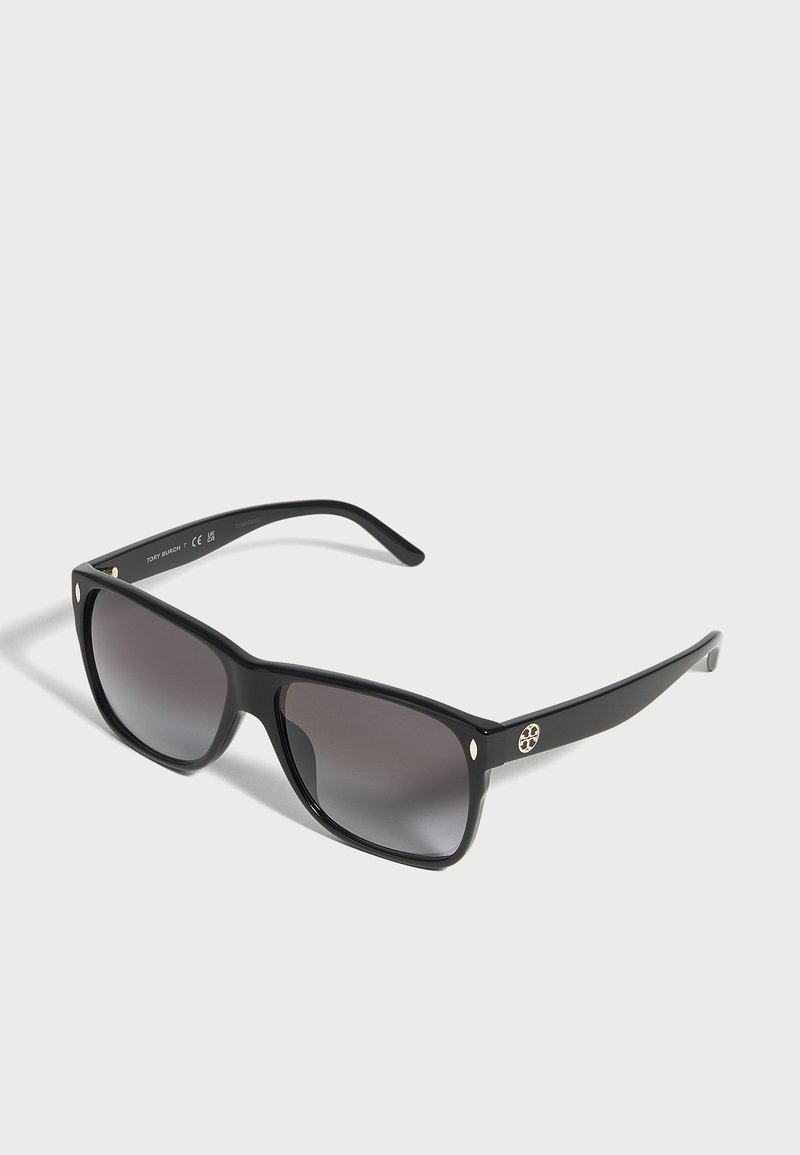 Lunettes de soleil noires Tory Burch à monture rectangulaire, verres gris dégradés et détails dorés sur les branches.
