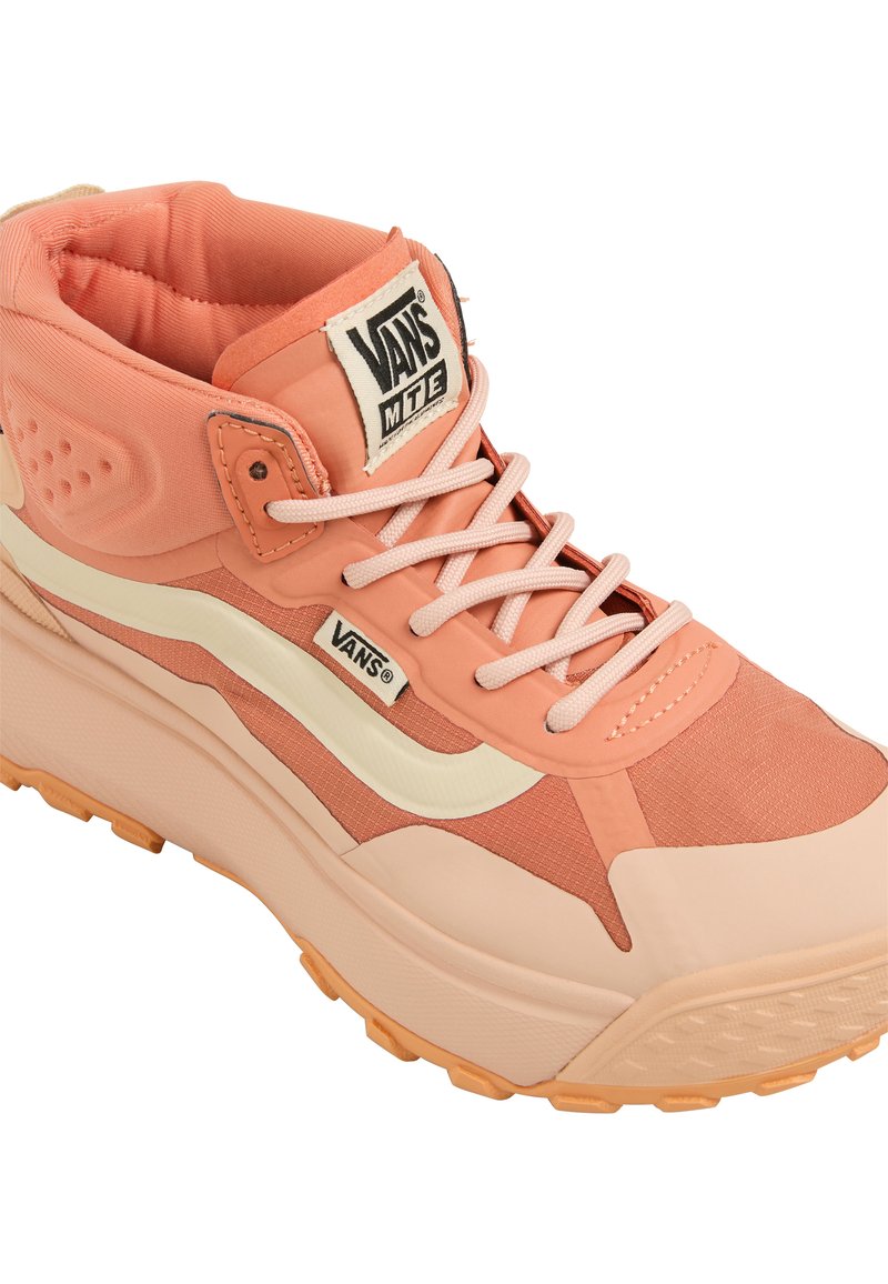 Zapatilla alta rosa con tejido texturizado, un collar acolchado, sistema de cordones y una franja de color crema en contraste a lo largo del lateral. Suela de goma.