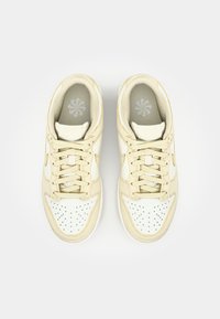 Cremfarbene Sneakers mit perforierter weißer Zehenkappe, tonalen Schnürsenkeln und weichem, strukturiertem Obermaterial. Verfügt über ein dezentes Logo und einen gepolsterten Kragen.