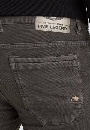 Szare spodnie z korduroy z wewnętrzną metką z napisem "PME LEGEND" na plecach. Tekstura jest prążkowana, z gładkim wykończeniem i subtelnymi detalami przeszyć.