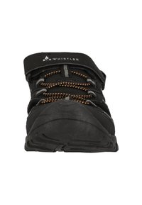 Svart sportskor med strukturerad ovandel, justerbar rem och orange detaljer på snörena. Böjd gummisula för bättre grepp.