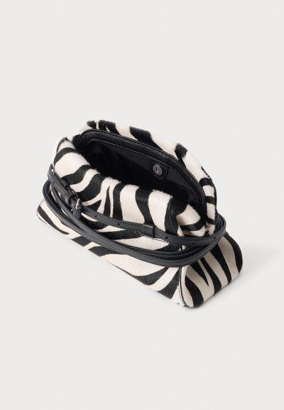 Petit sac à main imprimé zèbre avec bandoulière en cuir noir et rabat ouvert montrant l'intérieur noir et une fermeture pression.