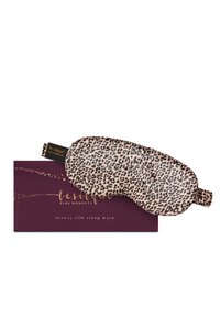 Maschera da sonno in seta con motivo leopardato poggiata su una scatola viola scuro etichettata "le silque" maschera da sonno in seta di lusso.