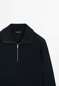 Navy knitted pullover with a quarter-zip, featuring a ribbed collar and shoulder design. Label reads "Massimo Dutti." Soft texture.