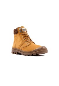 Bottines mi-hautes en daim brun avec une semelle en caoutchouc, œillets en métal et col rembourré. Présentent une finition lisse et un dessus texturé.