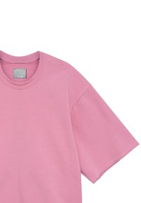 Różowa koszulka z krótkim rękawem z okrągłym dekoltem i gładką teksturą, z widoczną metką w pobliżu kołnierza.