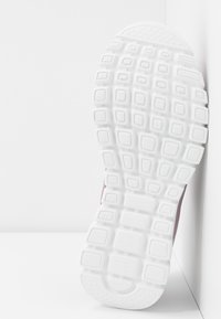 Biała gumowa podeszwa buta z teksturowanym wzorem zawierającym prostokątne i kwadratowe kształty oraz delikatnym zaokrągleniem w okolicy palców.