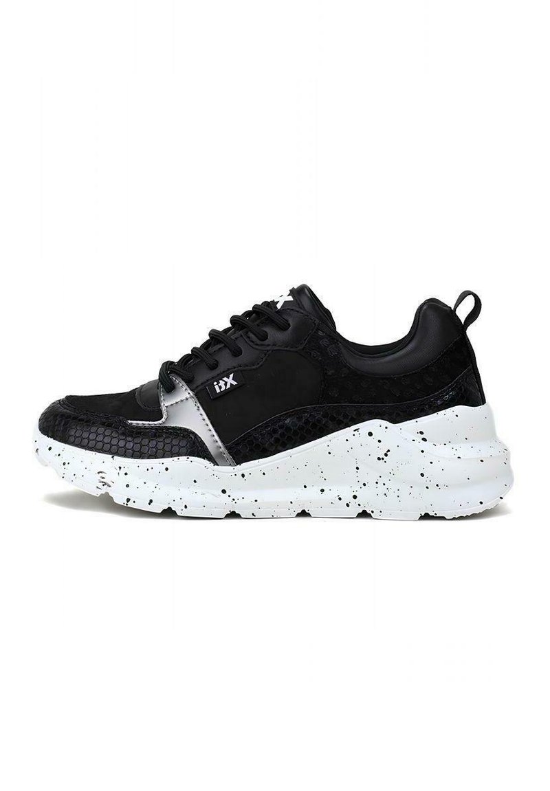 Sneaker nera con pannelli testurizzati, dotata di una tomaia in pelle liscia, suola bianca macchiata e lacci neri. Accentuata da un logo argentato.