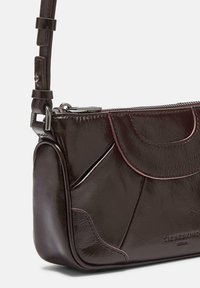 Borsa a mano in pelle bordeaux scuro con finitura tessurizzata, caratterizzata da cuciture curve e cuciture a contrasto, dotata di una corta tracolla regolabile.