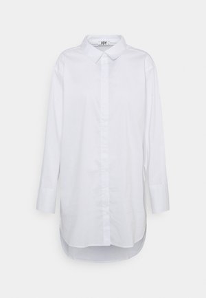 Hvid langærmet skjorte med knapkrave, lige snit og en let forlænget bagkant. Lavet af glat stof uden synlige mønstre.