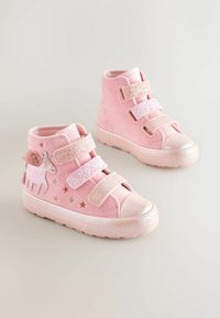 Rózsaszín magasszárú cipők, puha velúrból készült, két csillogó pánttal, egy unikornis folttal és csillag díszítésekkel az oldalán.