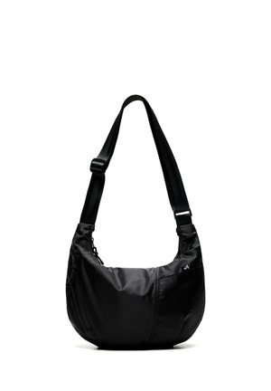 Sort crossbody-taske med justerbar rem, buet form og lille lynlåslomme på forsiden.