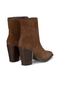 Bottines en suedine marron avec des talons en bois évasés et un léger bout en amande, présentant des détails de fermeture éclair lisses sur le côté.