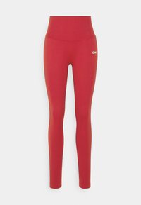 Leggings rossi con un alto elastico in vita, realizzati in tessuto liscio ed elastico. Presentano un piccolo logo visibile sull'anca sinistra.