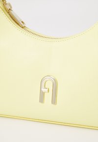 Gelbe Leder-Schultertasche mit einem metallisch-silbernen Logo-Akzent, glatter Textur und einem Reißverschluss.