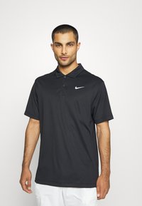 Schwarzes Nike Polo-Shirt aus leichtem Stoff, mit einem Kragen mit drei Knöpfen und einem weißen Nike-Logo auf der linken Brust.