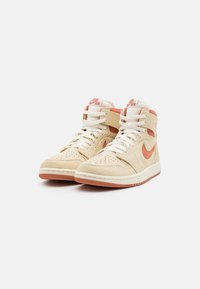 Beżowe sneakersy typu high-top z zamszowymi i siateczkowymi panelami. Posiadają pomarańczowe akcenty, perforowaną część na palce oraz białe sznurówki. Gumowa podeszwa z dobrą przyczepnością.