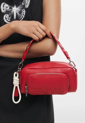Rote Lederhandtasche mit strukturiertem Finish. Sie verfügt über ein Hauptfach mit Reißverschluss, eine Fronttasche und einen abnehmbaren Tragegurt mit metallen Akzenten.