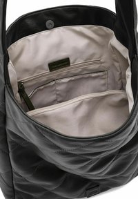 Zwarte gewatteerde leren shopper met een lichtbeige binnenkant, voorzien van een ritsvak en organisatievoorzieningen. Geribbelde textuur aan de buitenkant.